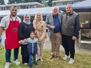 Bezoekers genieten van de najaarsbraderie bij de Şefaat Moskee in Heerenveen, met kleurrijke kraampjes, gerechten en ontmoetingen in een warme sfeer.